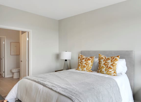 a bedroom with a large bed and a door to a bathroom