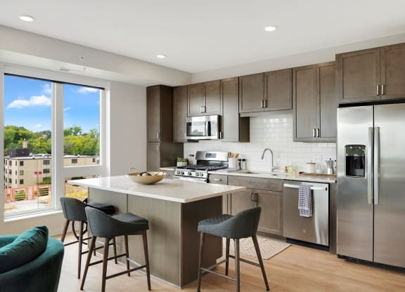 a kitchen with a large island and stainless steel appliances