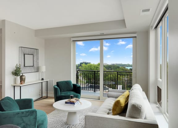 a living room with a white couch and two green chairs