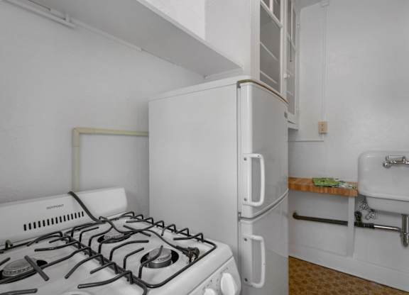 A small white kitchen with a stove and a refrigerator.