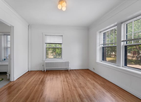 a bedroom with hardwood floors and white walls