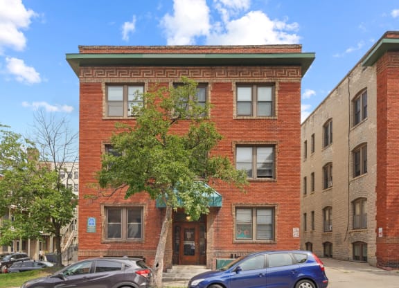 a red brick building with a tree in front of it