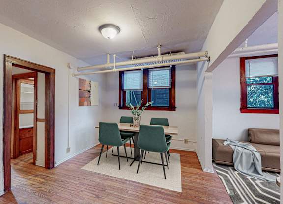 A room with a dining table and chairs.