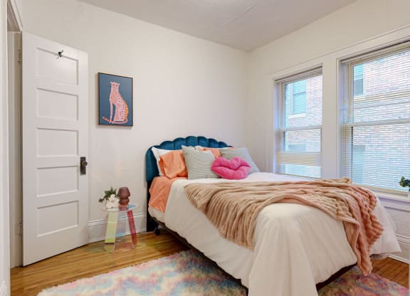 a bedroom with a bed and two windows