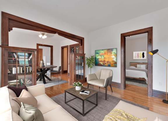 A living room with a white couch, a coffee table, and a painting on the wall.