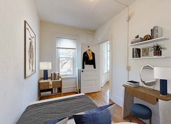 A bedroom with a bed, desk, and chair.