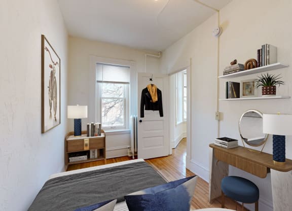 a small bedroom with a bed and a desk