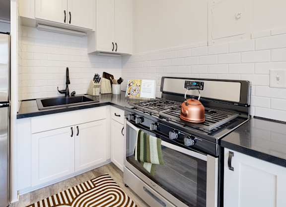 A modern kitchen with a stove top oven and a refrigerator.