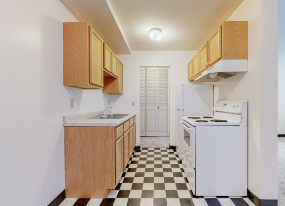 a kitchen with white appliances and a checkered floor