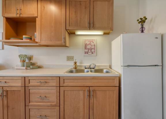 A kitchen with wooden cabinets and a white refrigerator.