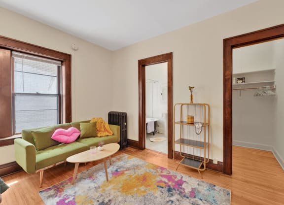 a living room with a green couch and a rug