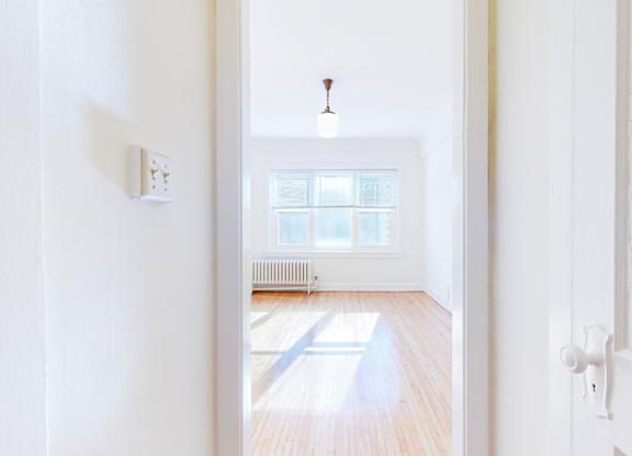 A white hallway with a light on and a door on the right.