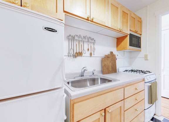 A kitchen with wooden cabinets and white appliances.
