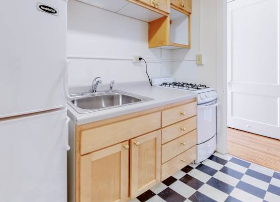 A white fridge sits next to a sink in a kitchen.