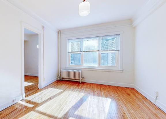 A room with a window and a radiator on the wall.