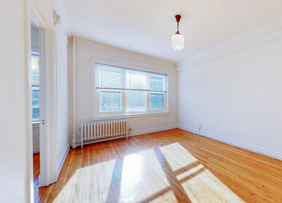 A room with a wooden floor and a window.