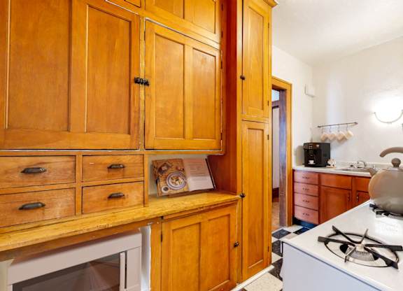 A kitchen with wooden cabinets and a white stove.