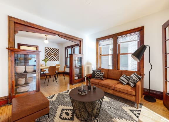 A Spacious Living Room with Retro Feel with Dark Hardwood Trim and Natural Light Streaming in from Large Windows at The Park Apartments in Minneapolis, MN, 55403