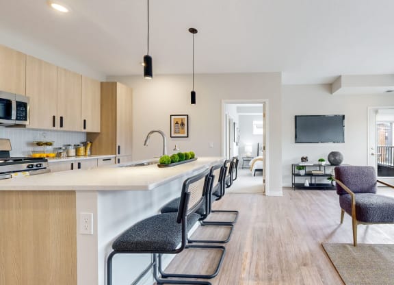 a kitchen and living room with chairs and tv