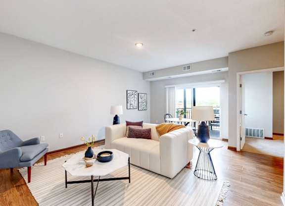 A living room with a white couch and a grey chair.