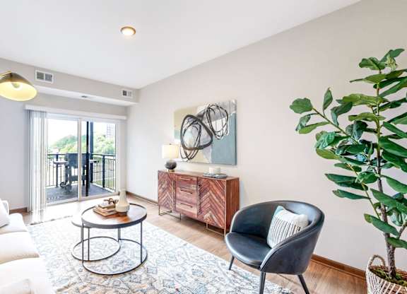 A living room with a white sofa, a black chair, and a round coffee table.