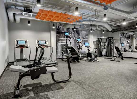a spacious workout room with treadmills and other exercise equipment