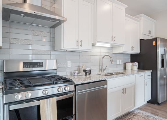 a kitchen with white cabinets and stainless steel appliances at The Yards and Backyards, Minnesota, 55075