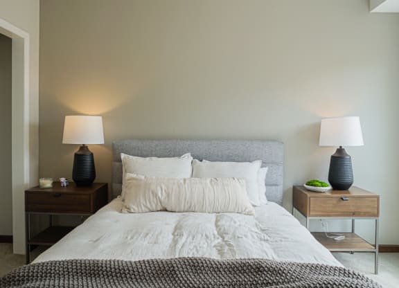 a bedroom with a bed and two nightstands with lamps on them at The Yards and Backyards, MN 55075