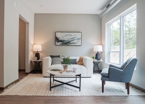 a living room with a couch and a chair and a window
