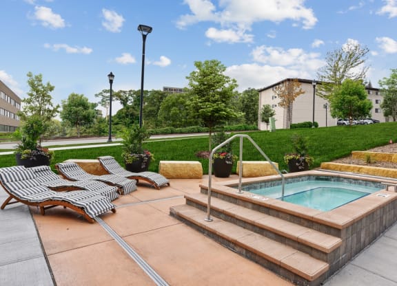 a pool and lounge chairs in a yard with a building in the background