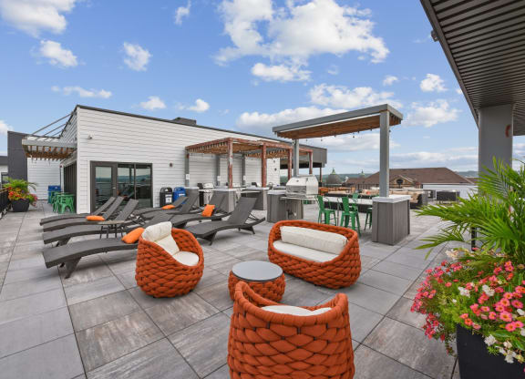 a patio with chairs and tables and a building in the background