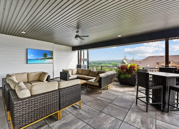a covered patio with couches and a table and chairs