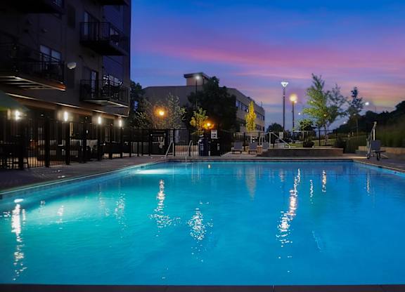 A swimming pool is lit up at dusk.