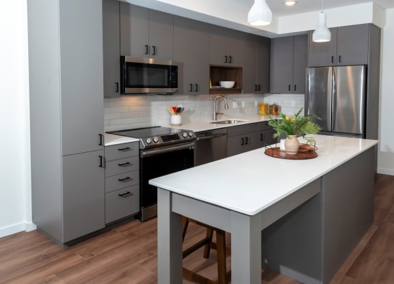 a kitchen with gray cabinets and a white counter top at Tyler Street Stacks, Minneapolis