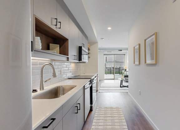 A modern kitchen with a white countertop and stainless steel appliances.at Tyler Street Stacks, Minneapolis