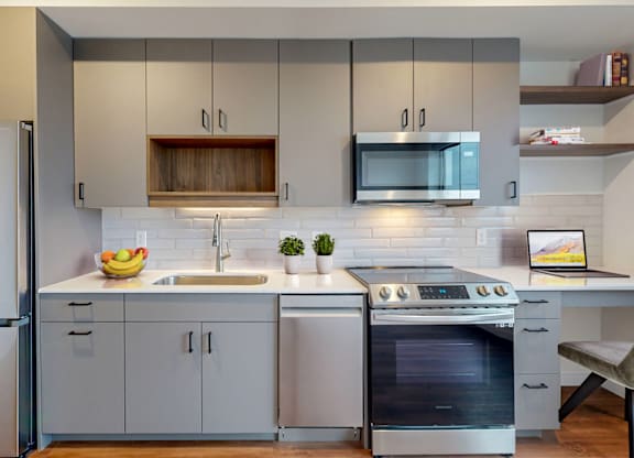 A modern kitchen with a stainless steel oven and a white fridge.at Tyler Street Stacks, Minneapolis, 55413