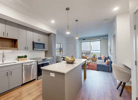 A modern kitchen with a dining area in the background.at Tyler Street Stacks, Minneapolis, MN 55413