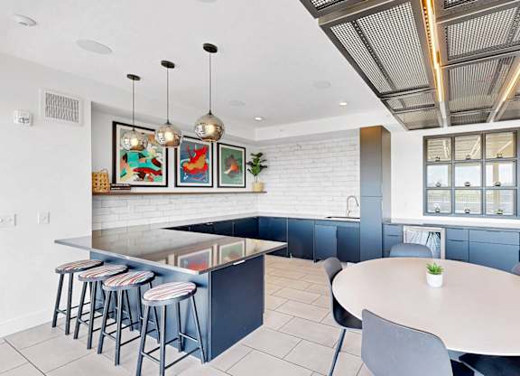 A modern kitchen with a bar area and a dining table.