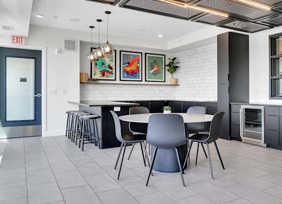 A modern dining area with a white brick wall and a black and white chair set.