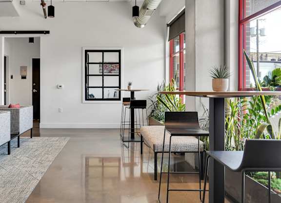 A modern living room with a grey sofa and a glass table.