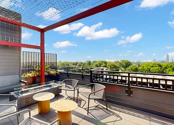 A red and white balcony with a table and chairs.