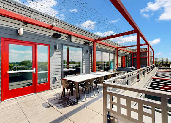 A red building with a white table and chairs outside.