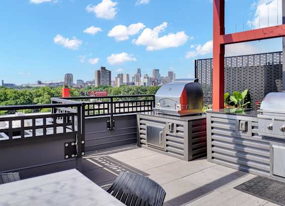 A modern outdoor kitchen with a grill and a table.