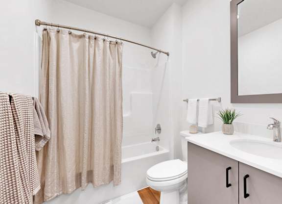 A bathroom with a toilet, sink, and shower.