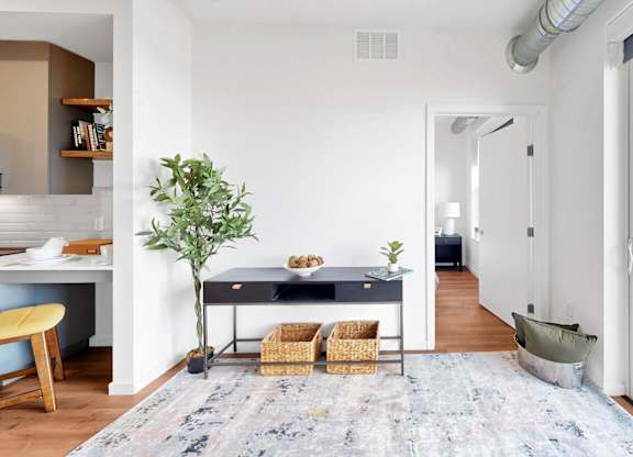 A room with a desk, chair, and a potted plant.