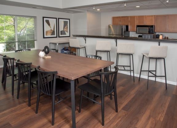 UPI community room with table seating and kitchen at Urban Park I and II Apartments, Minnesota