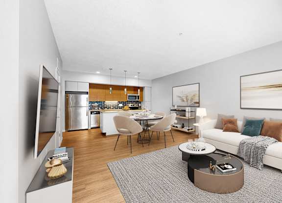 A modern living room with a kitchen in the background.