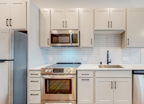 a kitchen with white cabinets and stainless steel appliances
