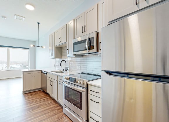 a kitchen with white cabinets and stainless steel appliances