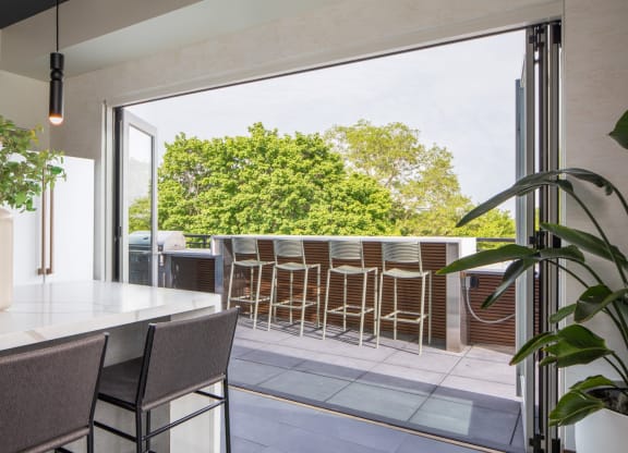 a kitchen with a large window that opens up to a terrace